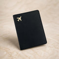 Chévereh black PU leather passport holder with a minimalist gold airplane emblem for travel organization.