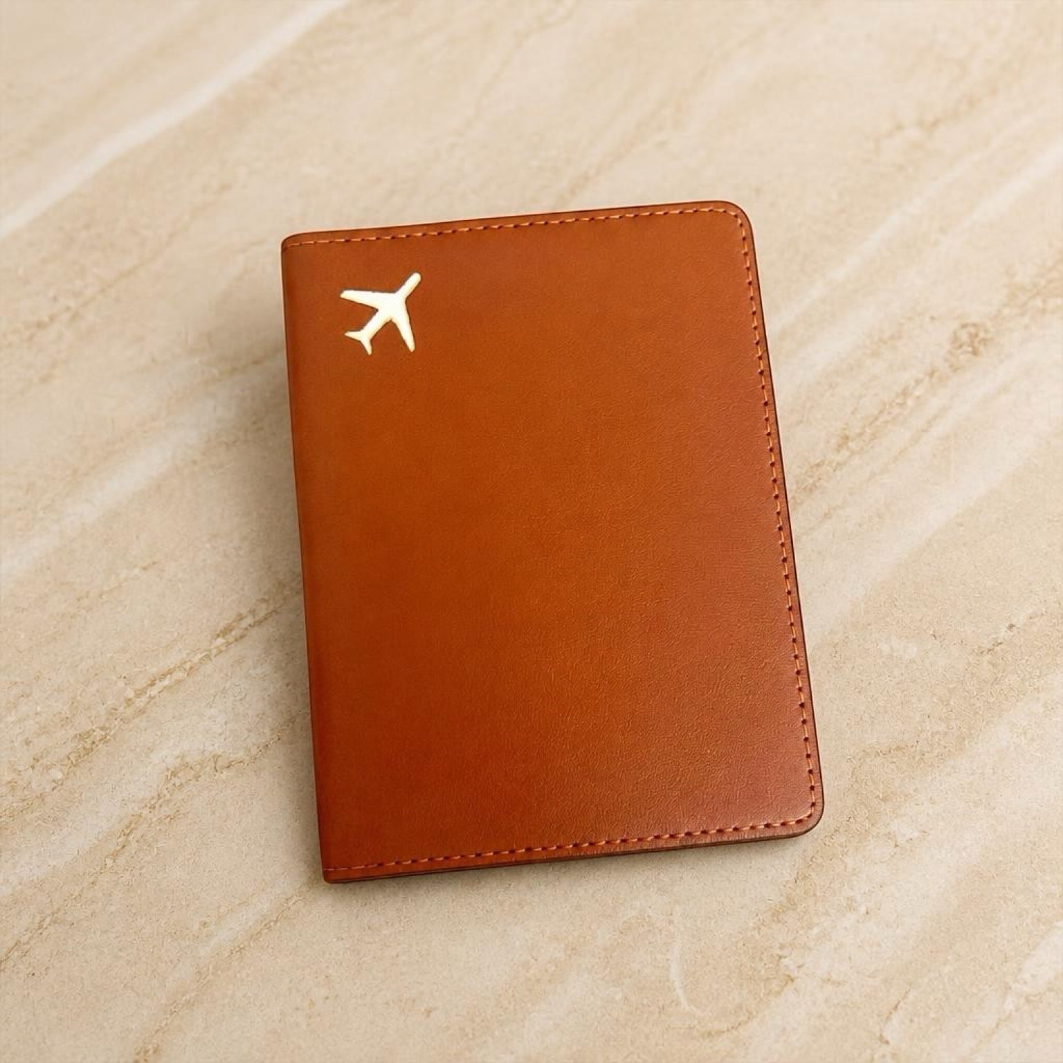 Chévereh brown PU leather passport holder case with a minimalist gold airplane emblem for travel organization.