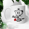Chévereh Ceramic Mug 11oz with a smiling greca coffee maker, red hibiscus flower, and text "Así se bebe aquí".
