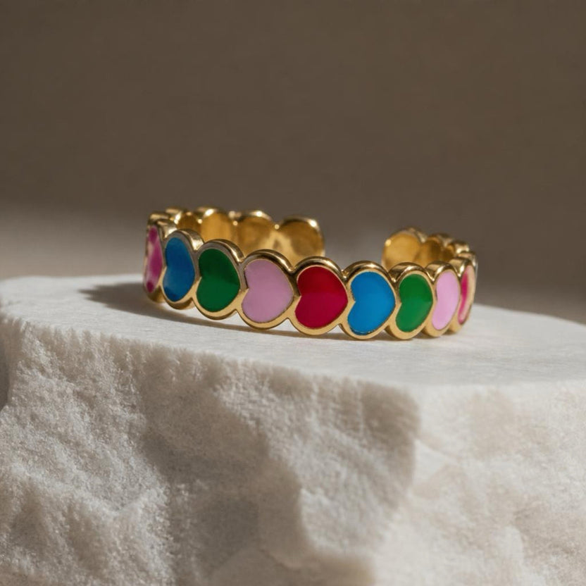 Chévereh gold-tone adjustable ring with colorful enameled hearts in pink, blue, green, and red.