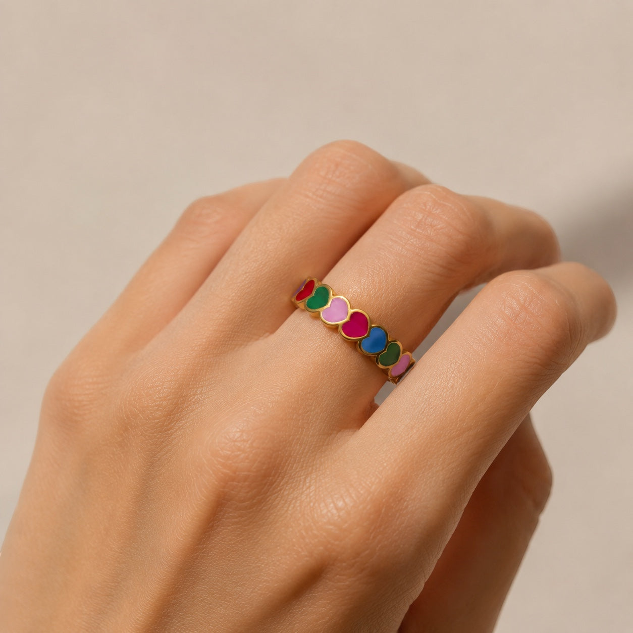 Chévereh gold-tone adjustable ring with colorful enameled hearts in pink, blue, green, and red.