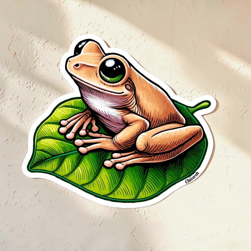 Chévereh Coquí Lindo vinyl sticker of a tan frog with large green eyes sitting on a vibrant green leaf. Waterproof, glossy finish.