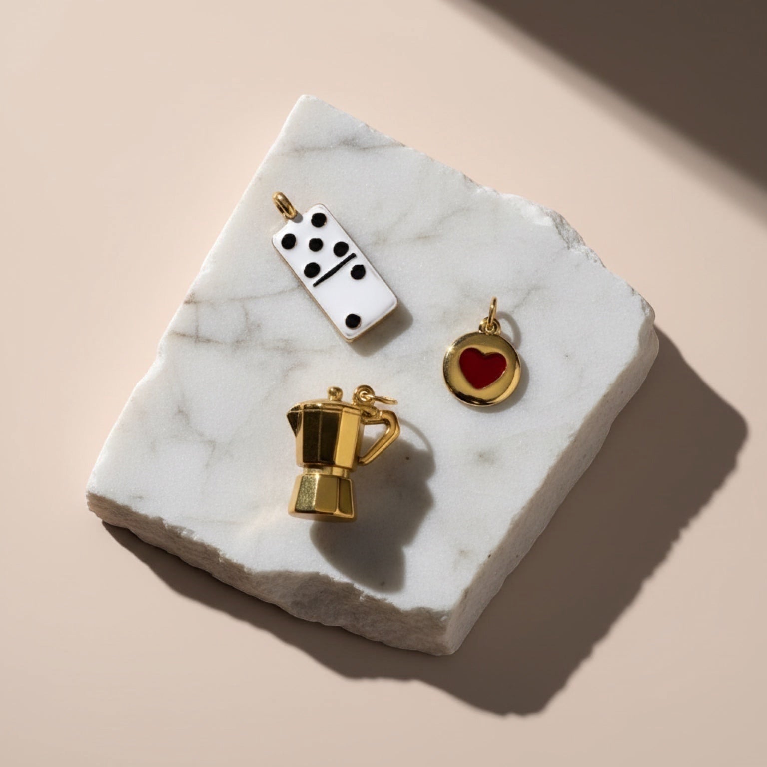 Chévereh gold moka pot, white domino, and red heart charms made of stainless steel.