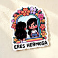 Chévereh Eres Hermosa vinyl sticker featuring a girl looking in a mirror surrounded by colorful flowers. Waterproof glossy finish.