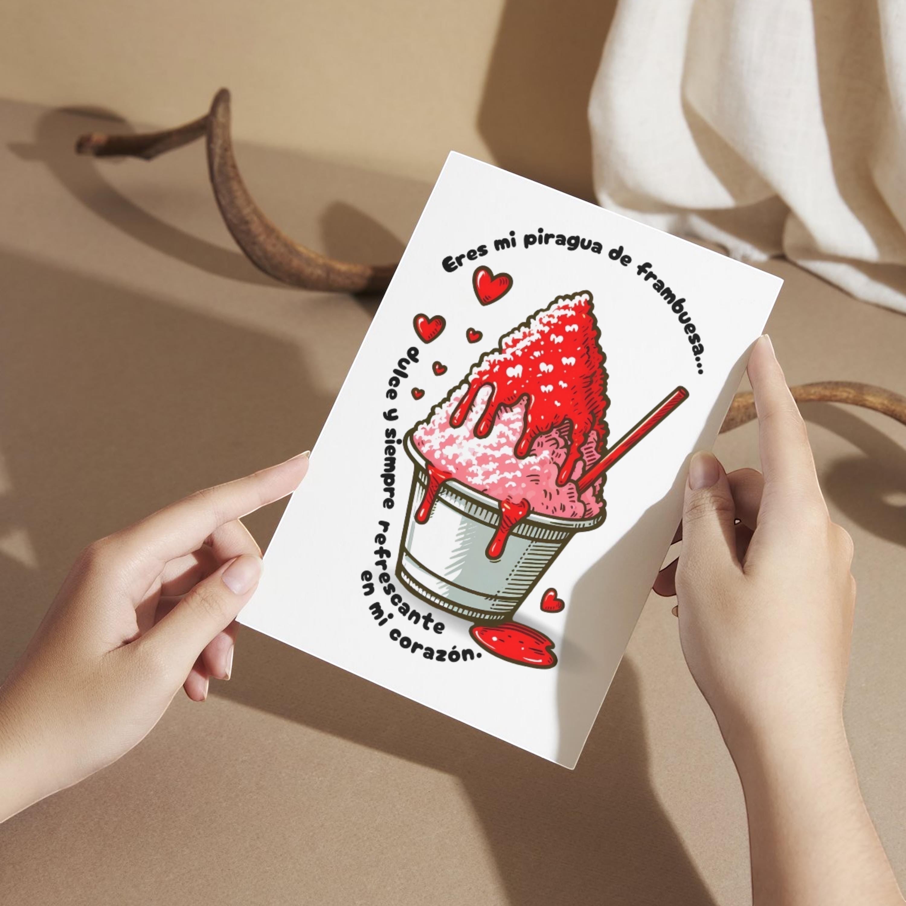 Hands holding a Chévereh digital postcard featuring a raspberry piragua illustration with red hearts and romantic text.