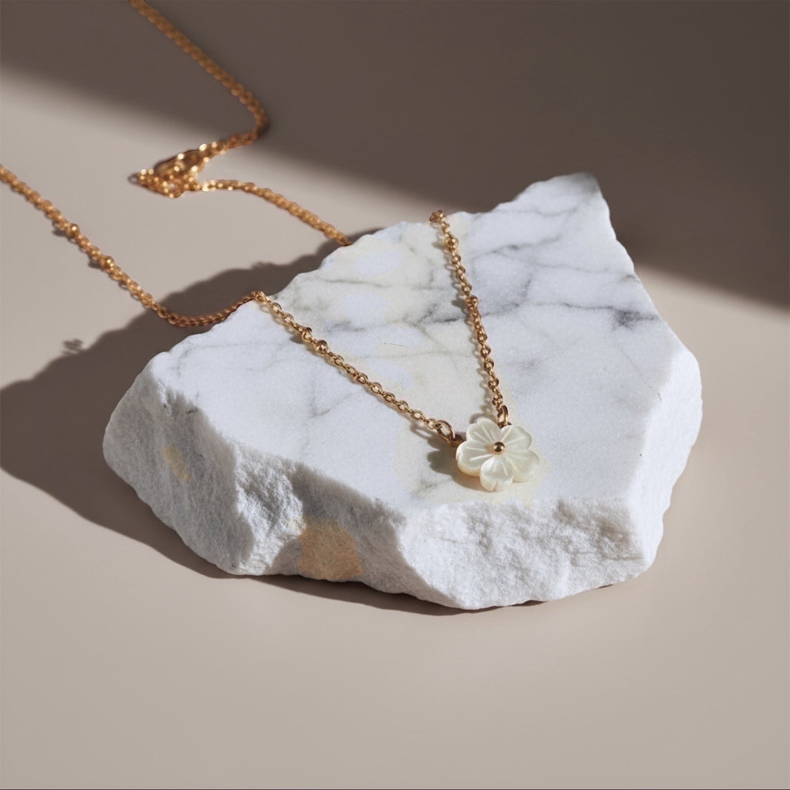 Chévereh delicate mother-of-pearl flower pendant necklace with gold-tone chain and bead accents.