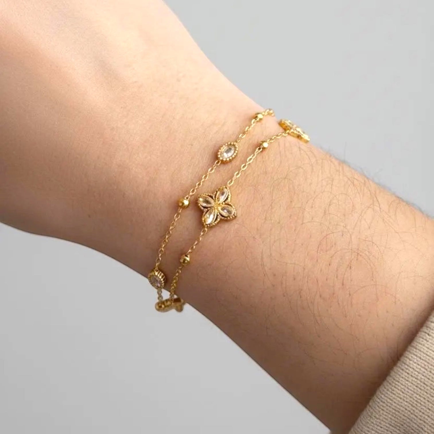 Chévereh gold double-chain bracelet with four-leaf clover charms and clear crystals. Made from 304 stainless steel.