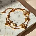 Chévereh gold double-chain bracelet with four-leaf clover charms and clear crystals. Made from 304 stainless steel.