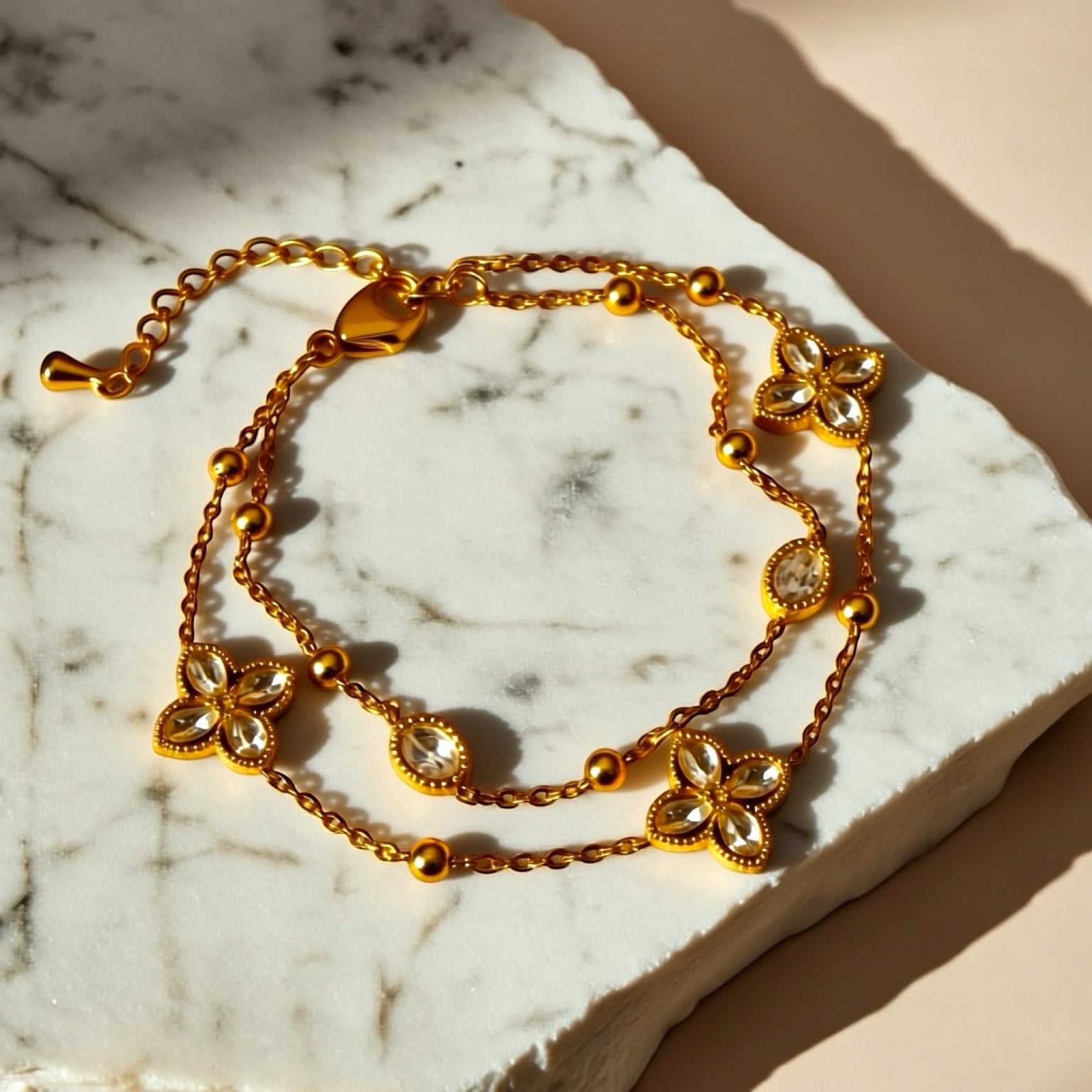 Chévereh gold double-chain bracelet with four-leaf clover charms and clear crystals. Made from 304 stainless steel.