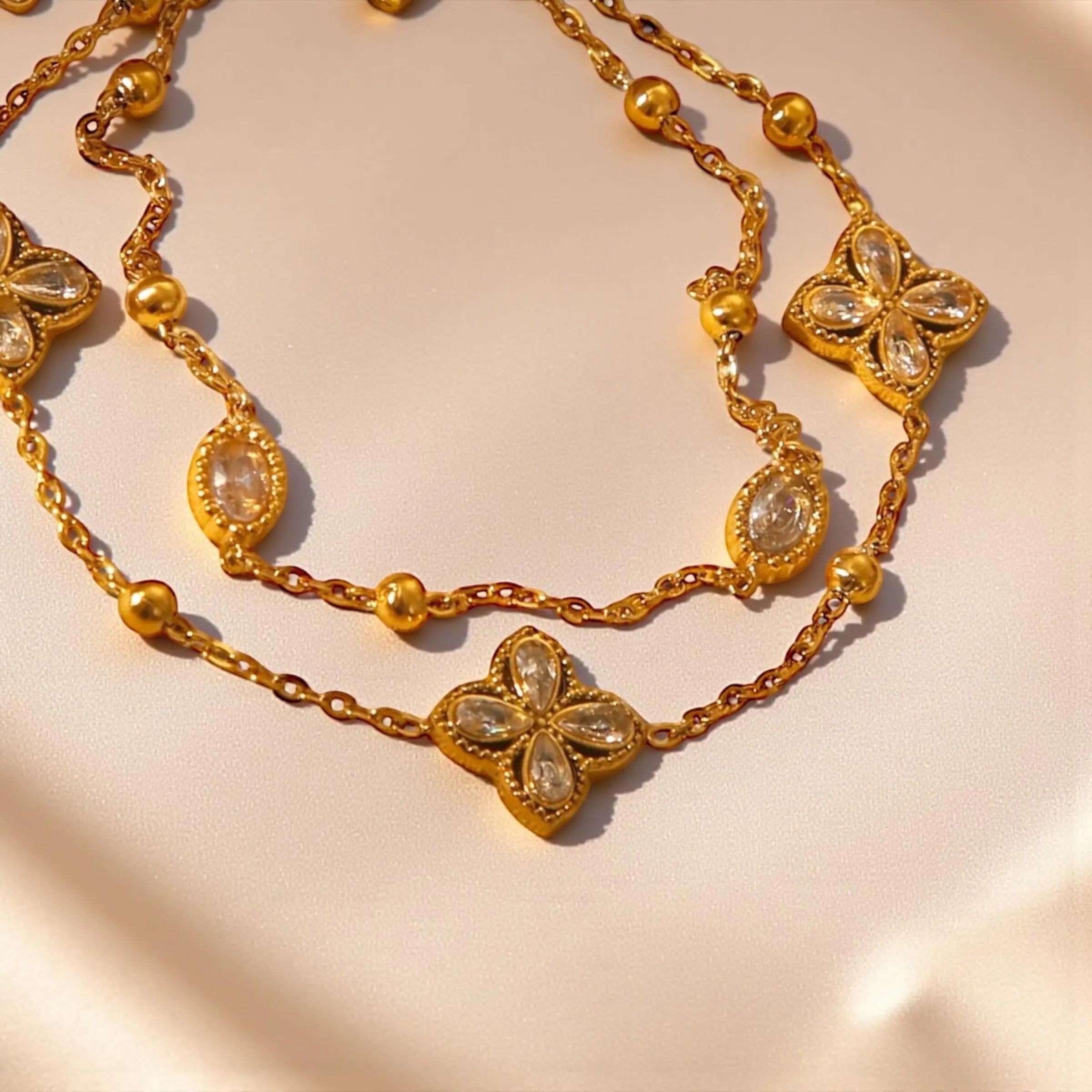 Chévereh gold double-chain bracelet with four-leaf clover charms and clear crystals. Made from 304 stainless steel.