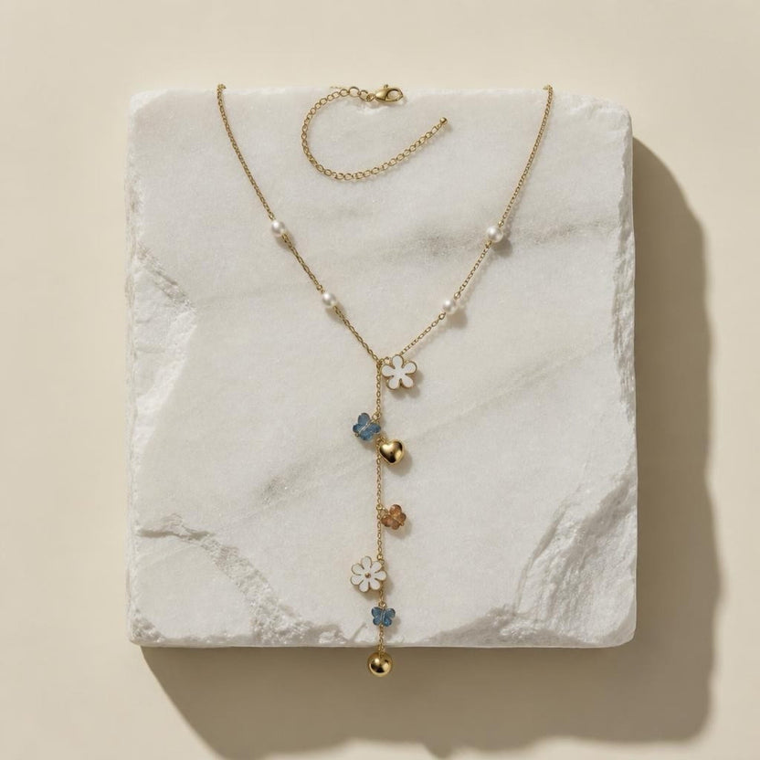 Chévereh gold-tone Y-necklace with faux pearls, white flower charms, blue butterflies, and polished gold hearts.