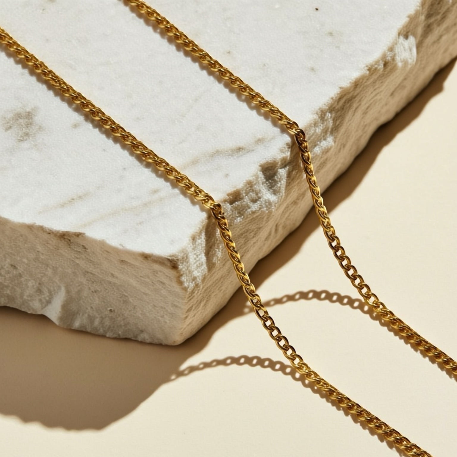 Chévereh gold-tone Greca charm necklace with a delicate chain, inspired by Italian coffee makers.