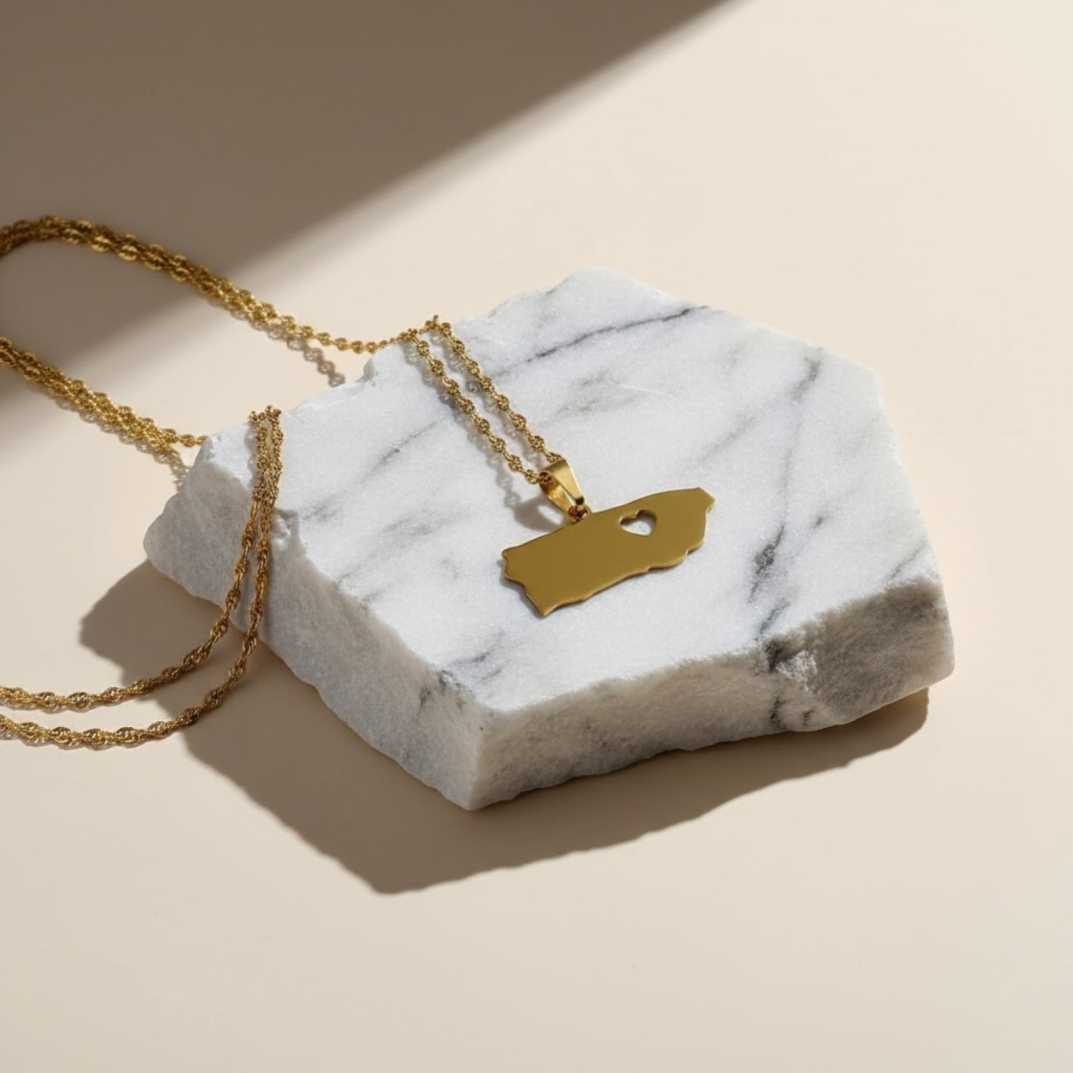 Chévereh gold-tone stainless steel island pendant necklace with heart cutout, minimalist design.