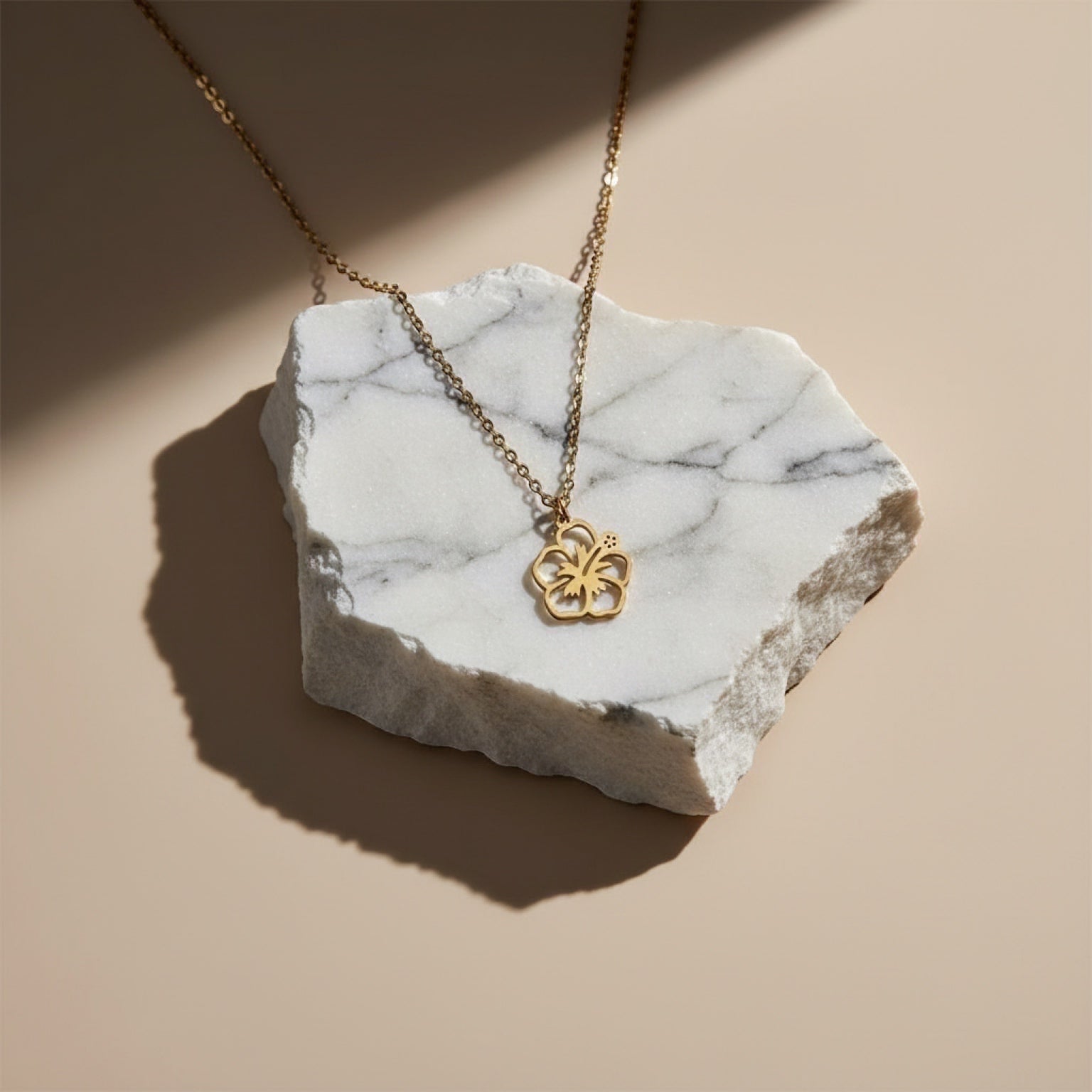 Chévereh gold-tone maga flower pendant necklace on a delicate chain, symbolizing beauty and joy.