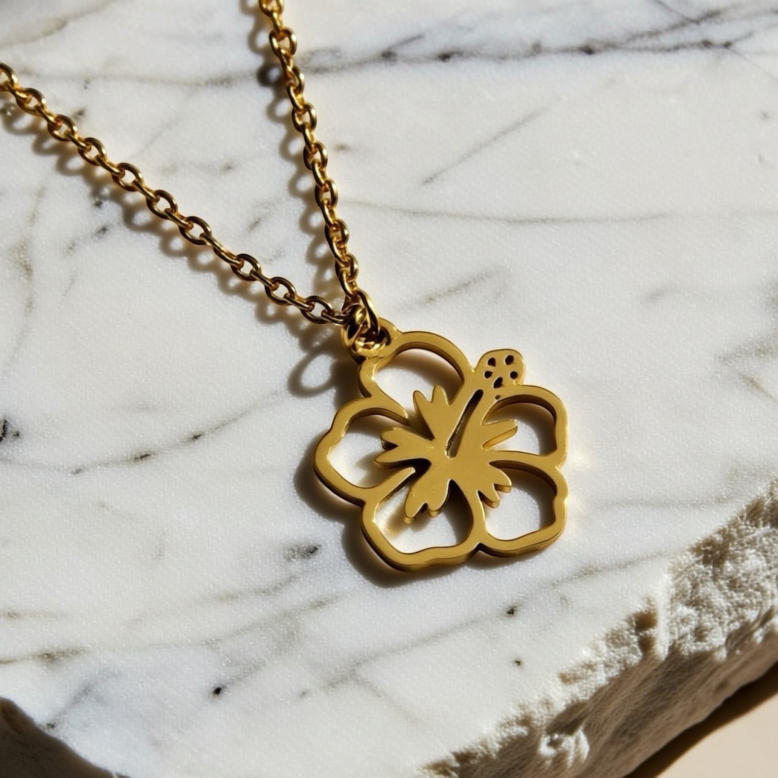 Chévereh gold-tone metal maga flower pendant necklace with delicate chain, symbolizing beauty and joy.