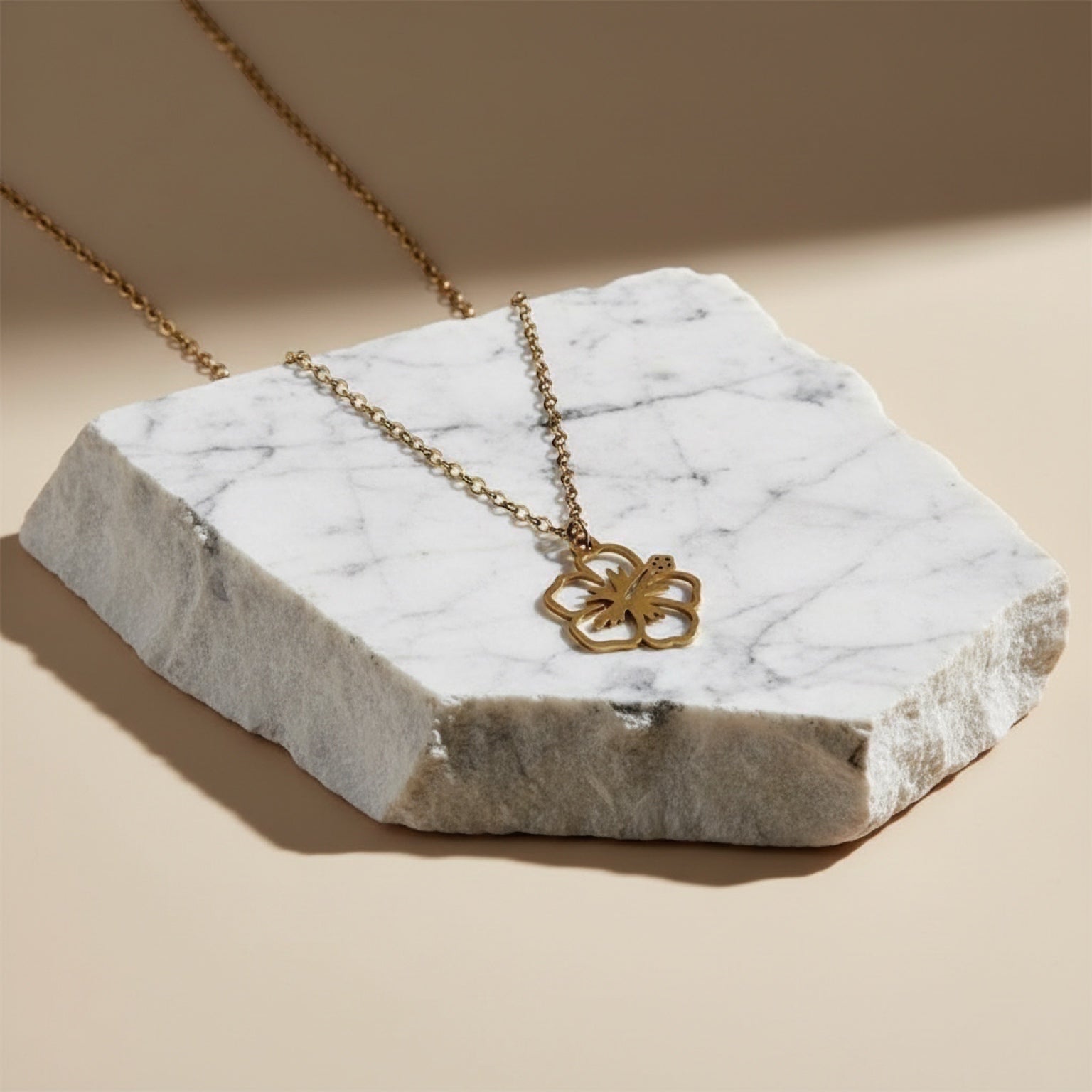 Chévereh gold-tone maga flower pendant necklace with a delicate chain. Minimalist floral design.