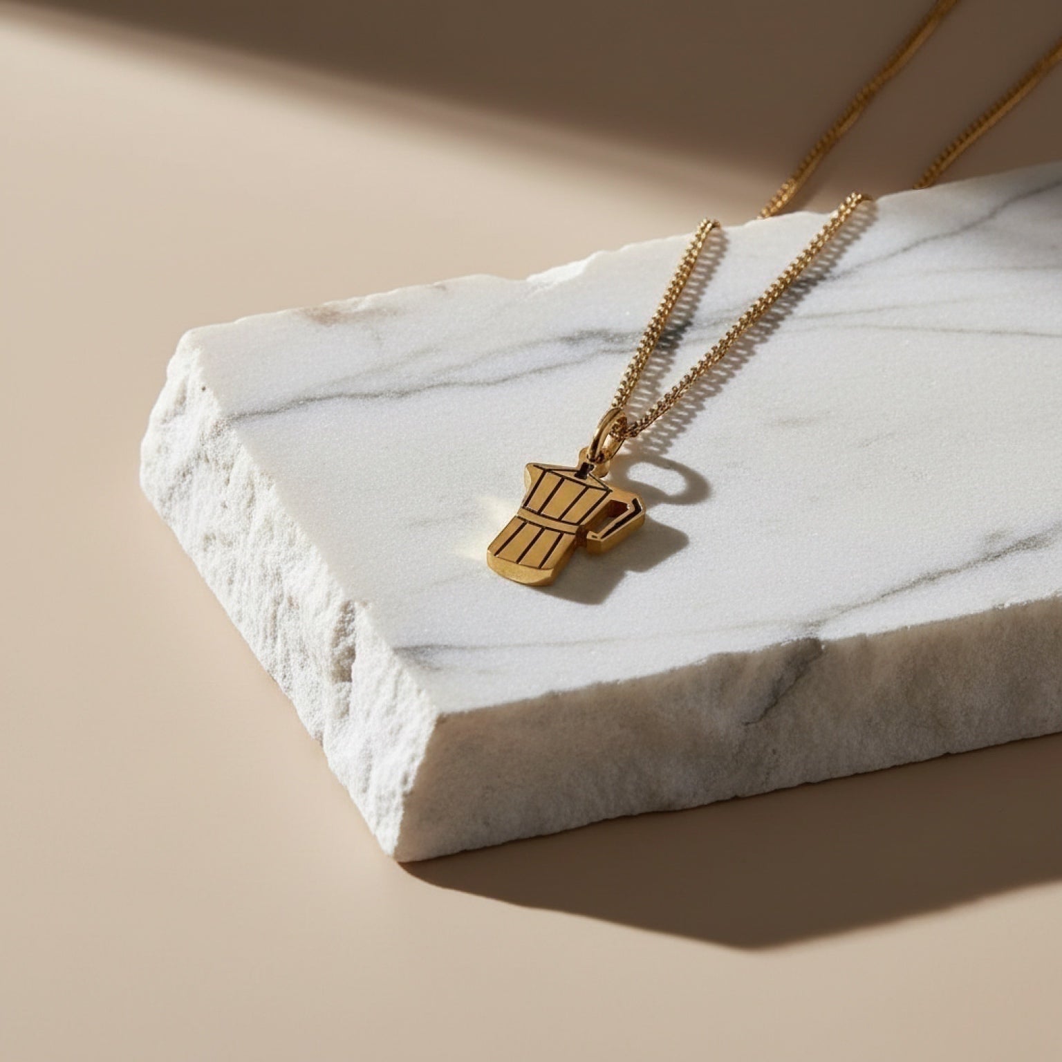 Chévereh gold-tone metal Greca necklace with a moka pot pendant on a delicate chain, perfect for coffee lovers.
