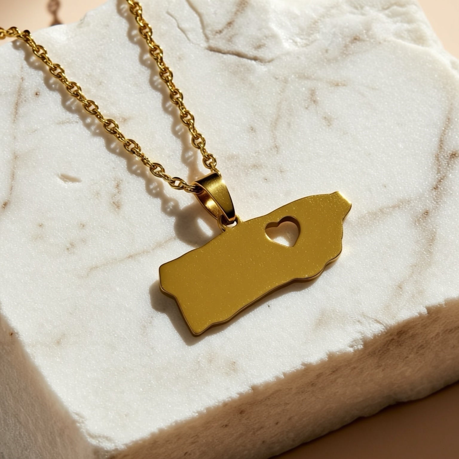Chévereh gold-tone stainless steel island pendant necklace with heart cutout, minimalist design.