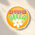 Chévereh La Vida Es Bella vinyl sticker with orange background, green lettering, and white flower detail.