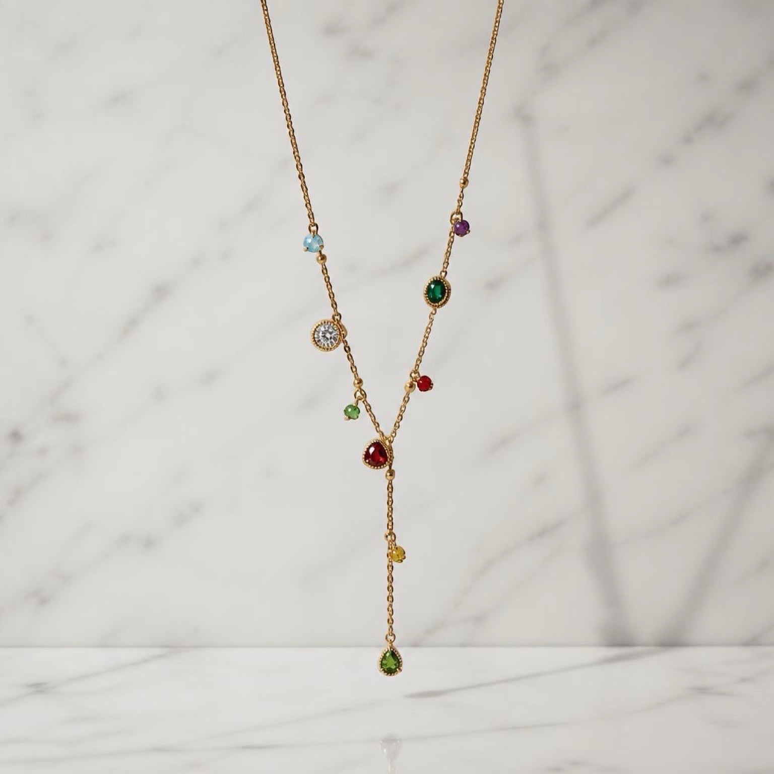 Chévereh dainty gold-tone stainless steel drop necklace featuring colorful multifaceted stones on a delicate chain.