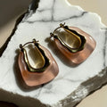 Chévereh sculptural gold-tone and blush-pink resin hoop earrings with a modern, artistic design.