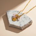 Chévereh Pinky Charm Necklace with gold chain, pink beads, gold coin, and rose quartz stone.