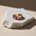 Chévereh adjustable gold-tone ring with colorful baguette-cut cubic zirconia stones.