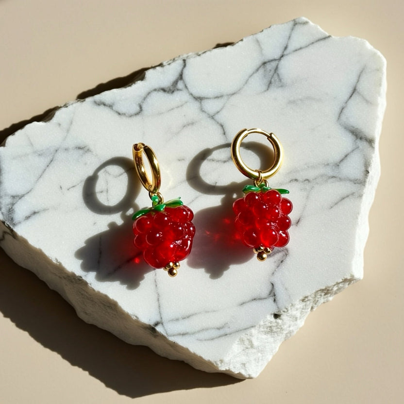 Chévereh Raspberry Glass Drop Earrings with red glass beads, green leaf accents, and gold hoops.