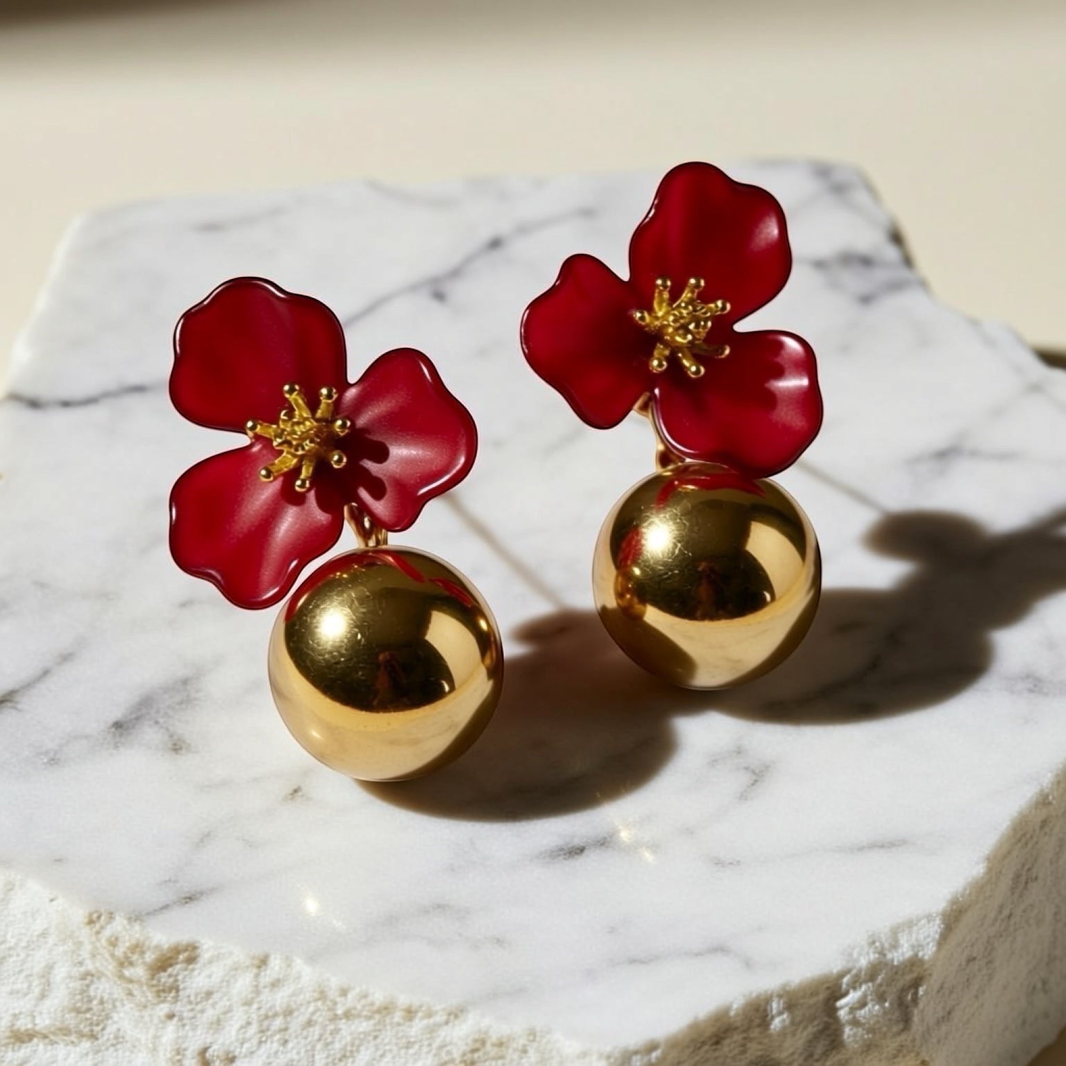 Chévereh red hibiscus floral ball drop earrings with gold centers and polished gold balls.