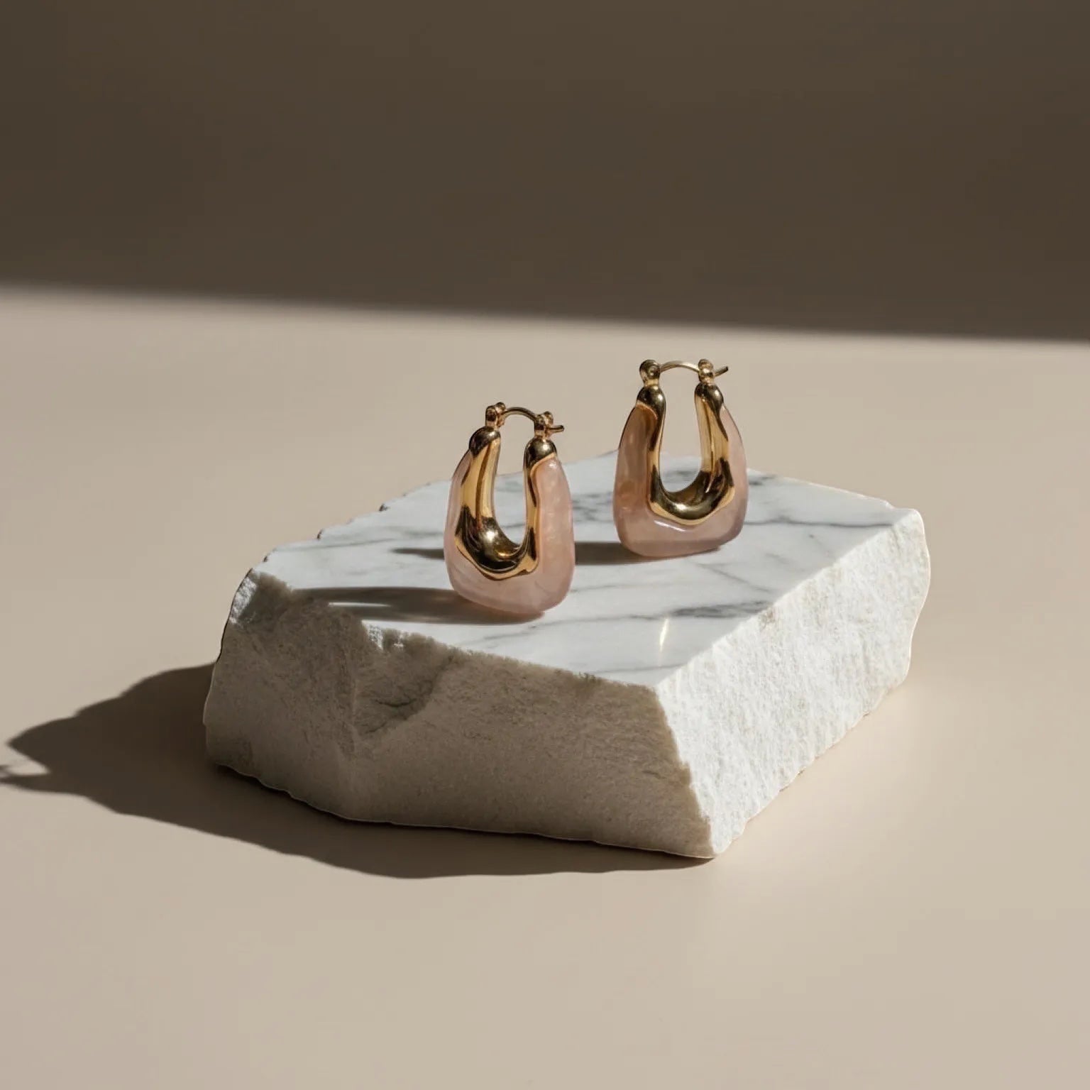 Chévereh gold-tone and blush pink resin sculptural hoop earrings with stainless steel posts.