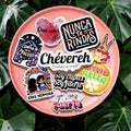 Chévereh glossy vinyl sticker pack with Latina-themed Spanish affirmations on a pink plate over green leaves.