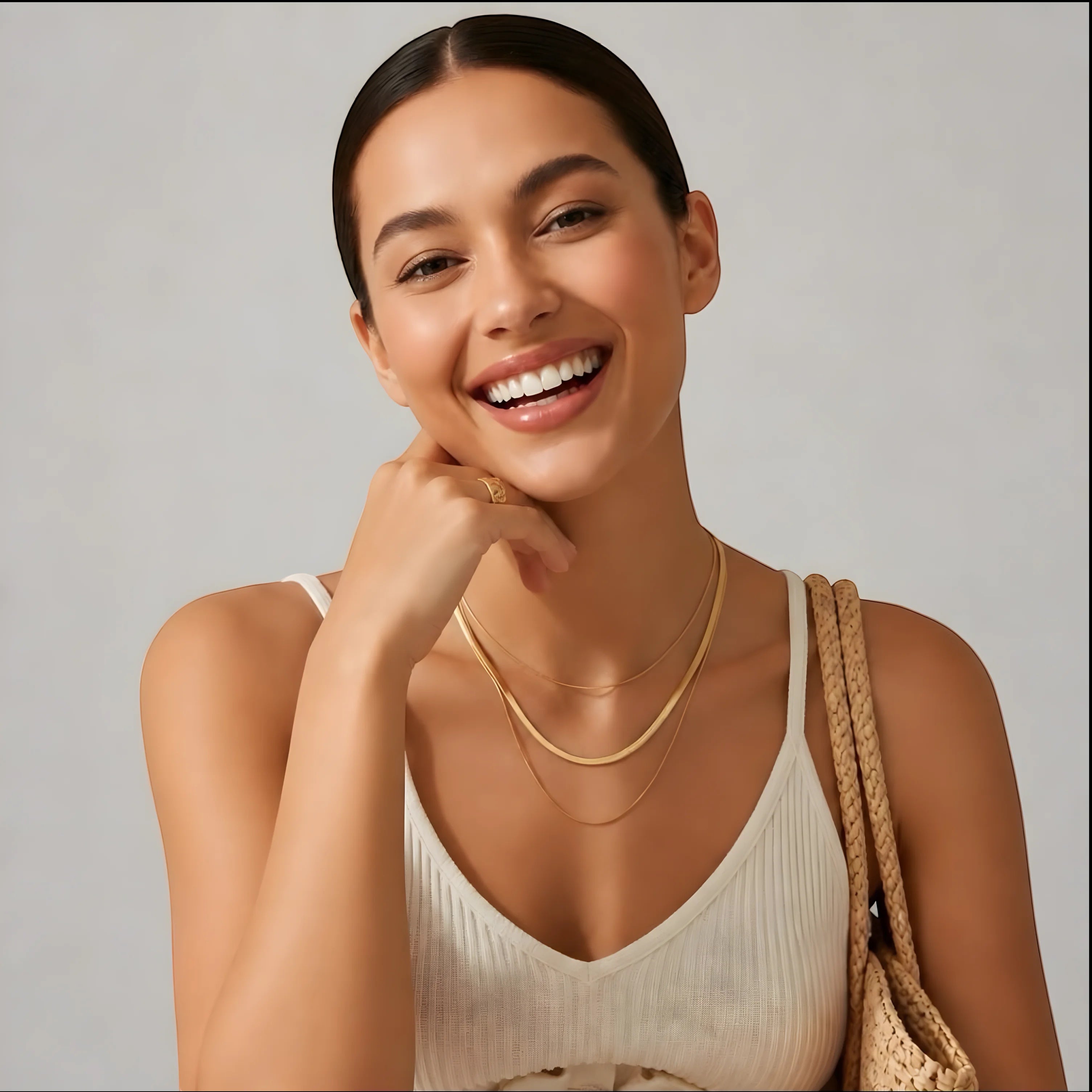 Model wearing a Chévereh three-layer gold-tone necklace with delicate chains and a white ribbed top.
