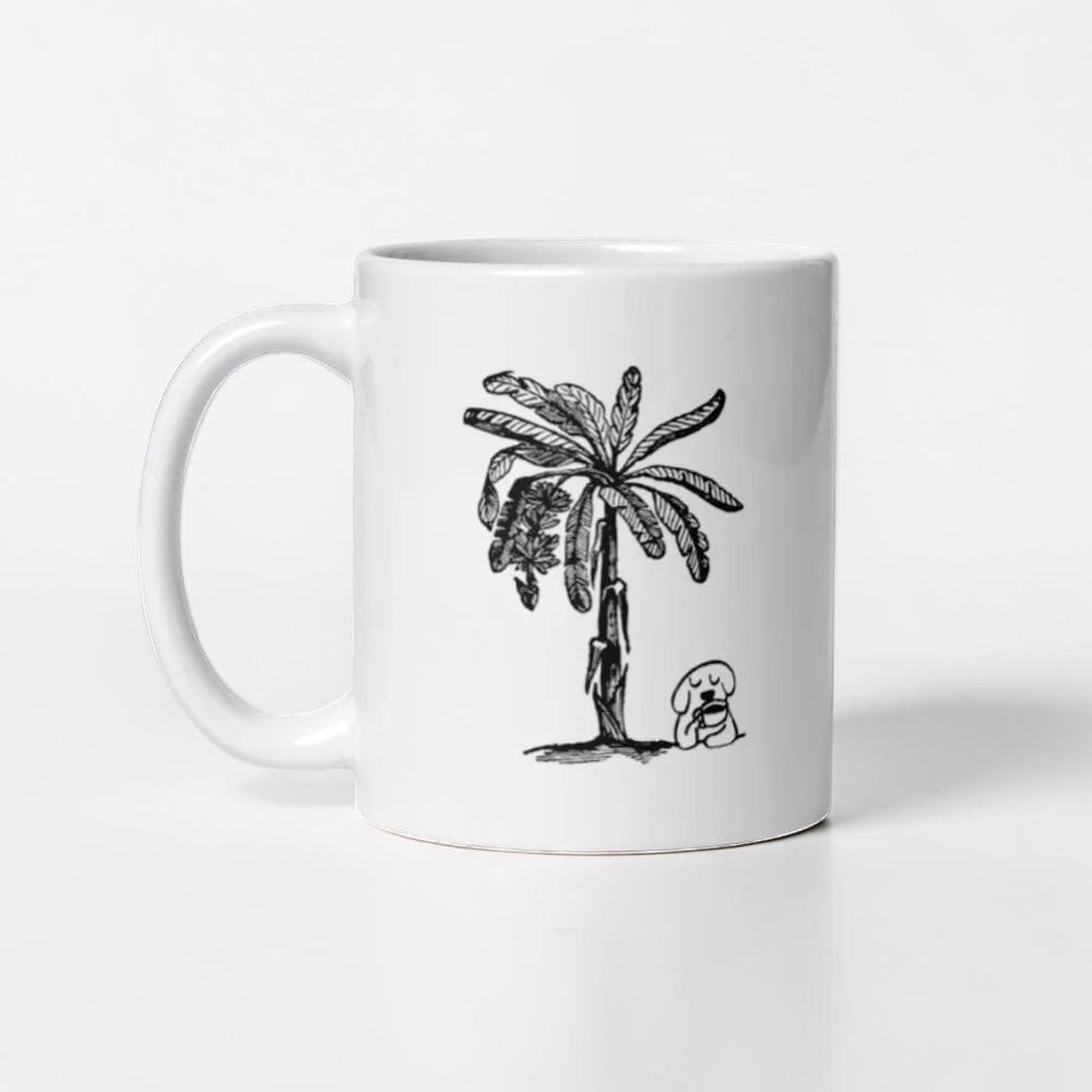 Chévereh white ceramic mug with a black line drawing of a palm tree and a dog drinking coffee.