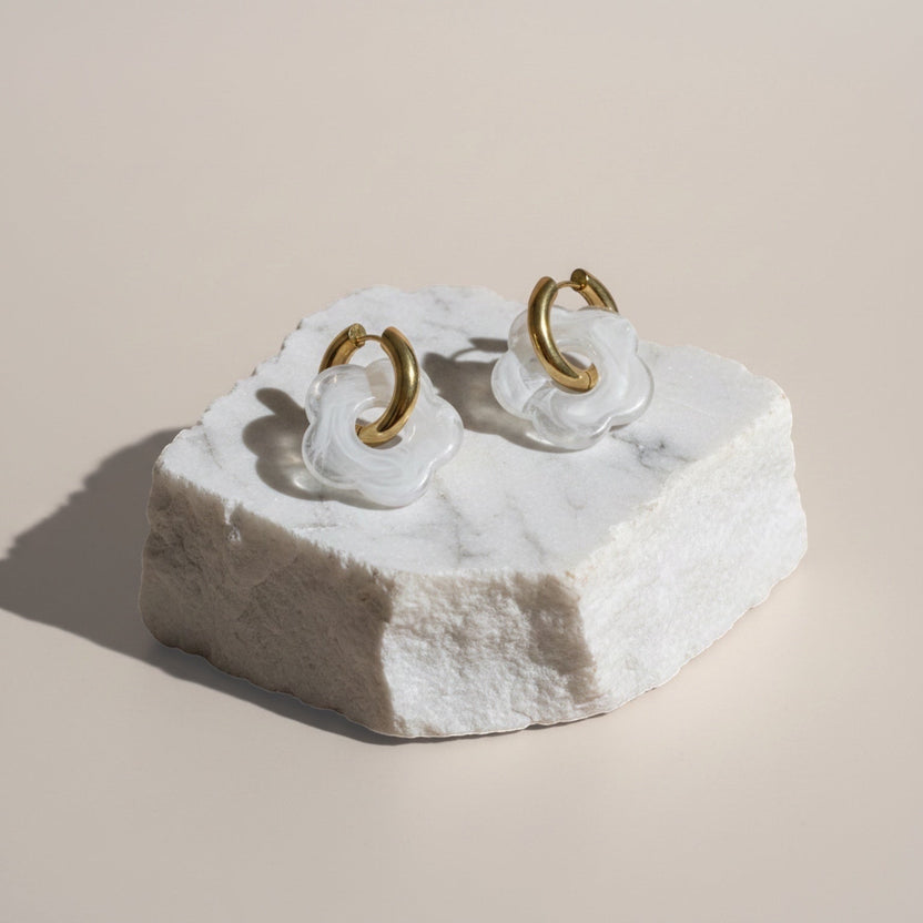 Chévereh White Bloom & Gold flower drop-style hoop earrings with translucent white charms and gold hoops.