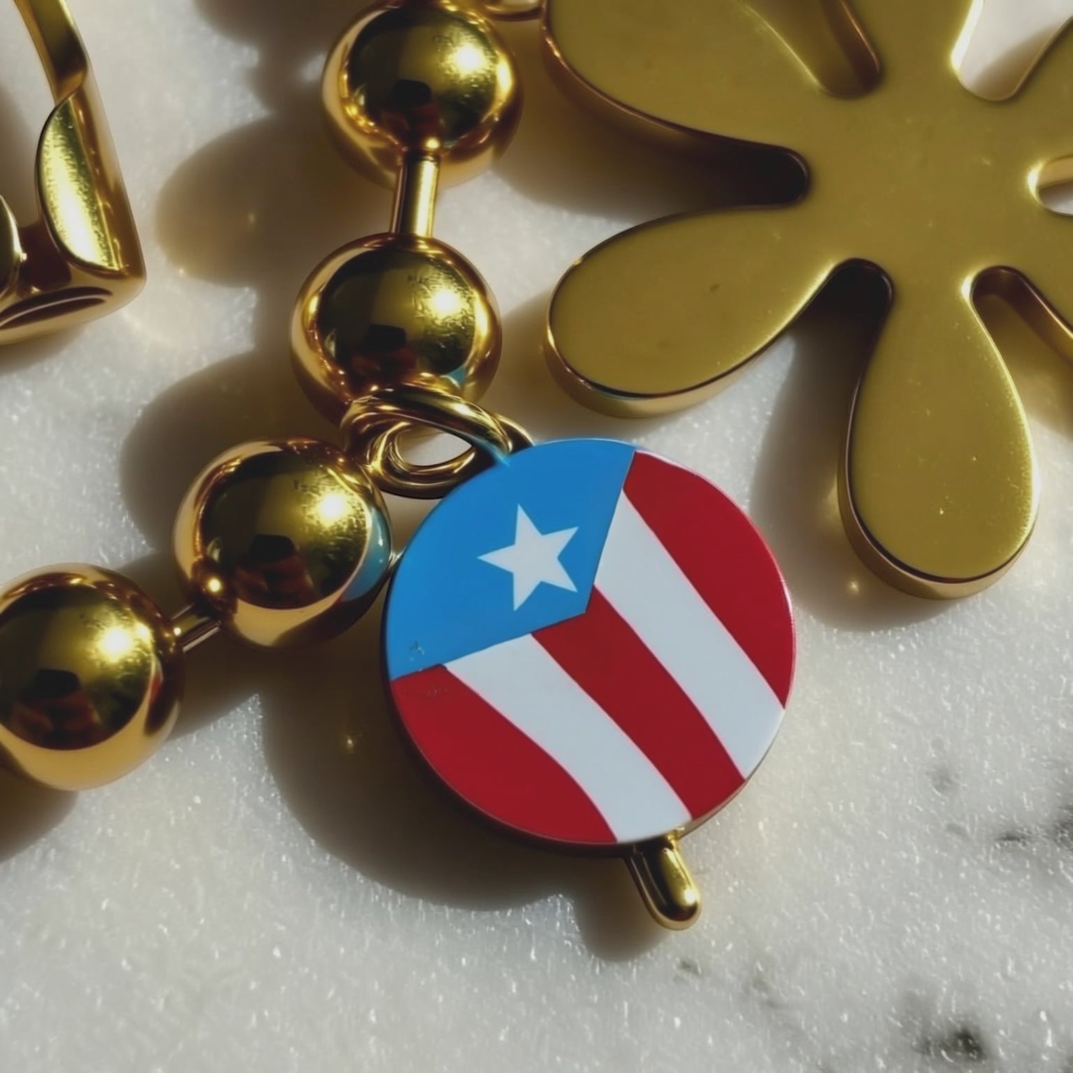 Chévereh gold-tone beaded bracelet with Puerto Rican flag charm and flower charm.