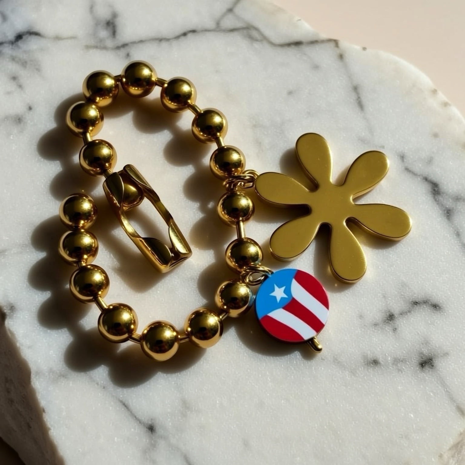 Chévereh gold-tone beaded bracelet with flower and Puerto Rico flag charms.