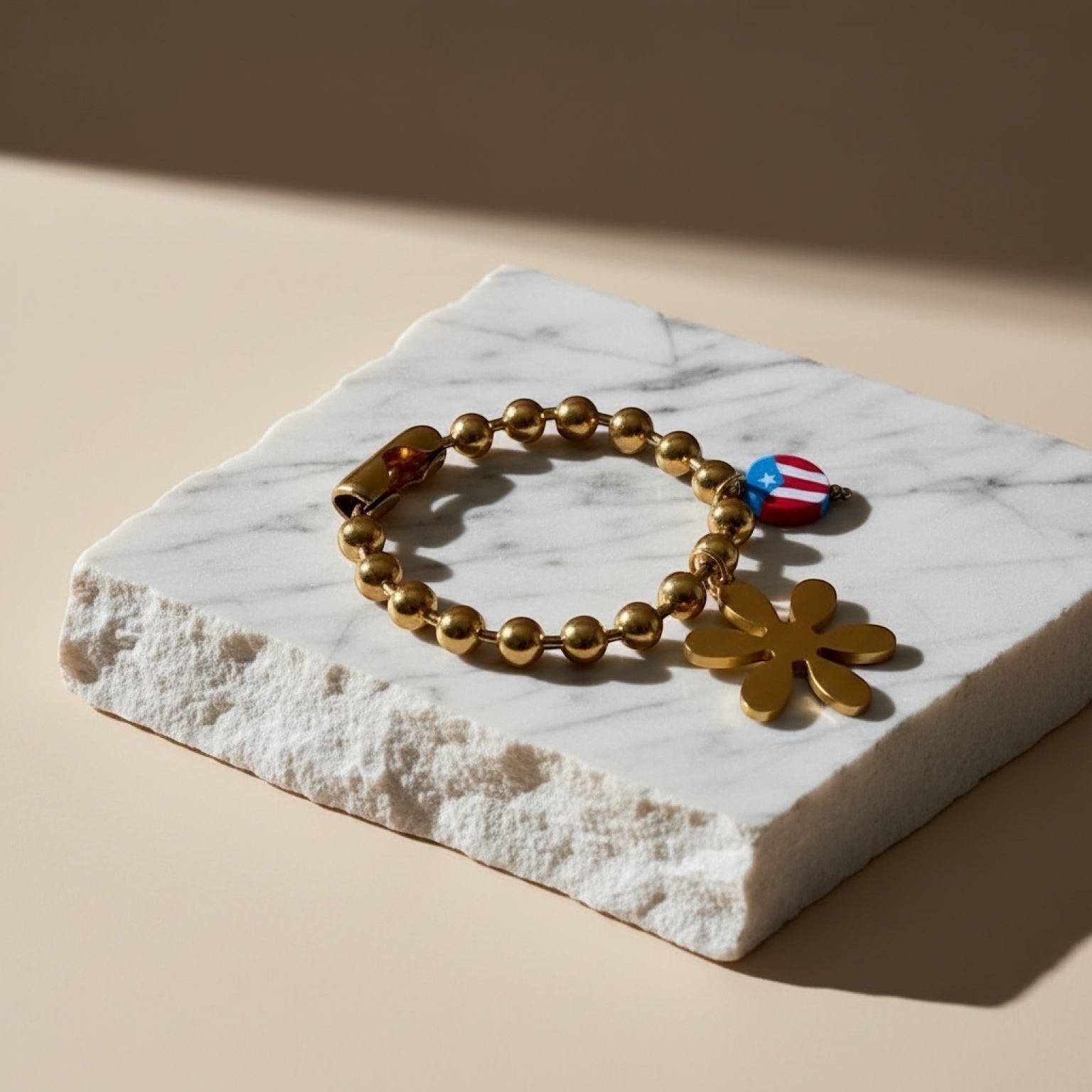 Chévereh gold-tone beaded bracelet with flower and Puerto Rican flag charms.
