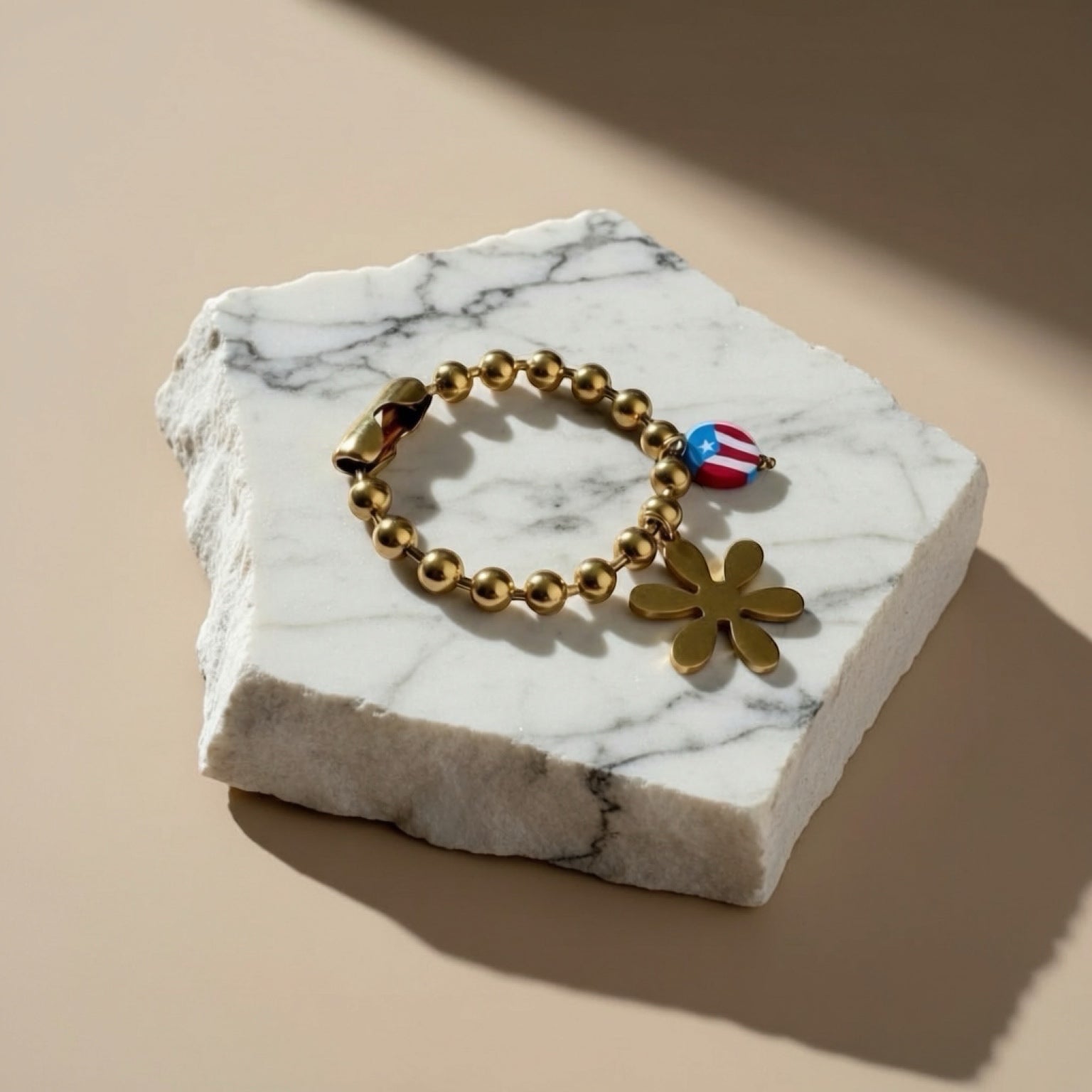 Chévereh gold-tone beaded bracelet with flower and Puerto Rico flag charms.